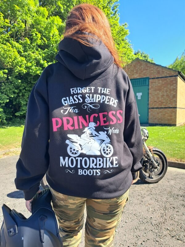 Woman wearing Motorbike Princess Hoodie holding helmet, showing back design