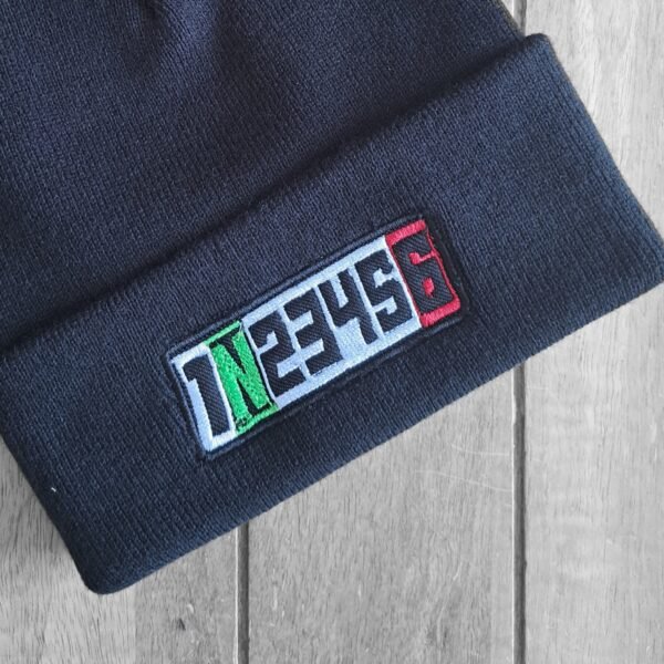 Front flatlay of black embroidered biker beanie with motorcycle gear shift numbers 1N23456 in vibrant colors