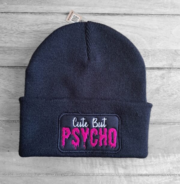 Cute But Psycho beanie on wooden surface