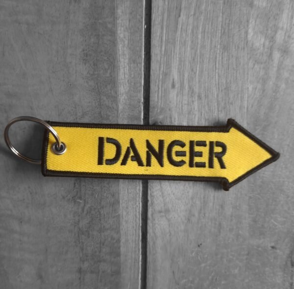 Close-up of yellow DANGER arrow embroidered biker keytag