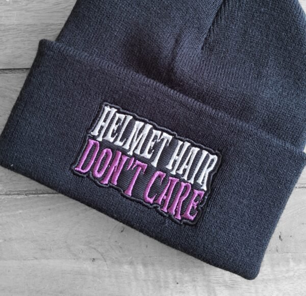 Close-up of Helmet Hair Don’t Care embroidered text on biker beanie