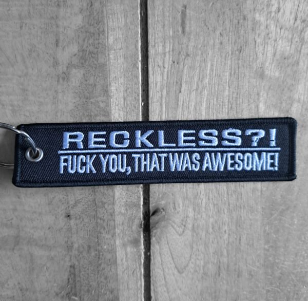 Close-up of RECKLESS?! embroidered biker keychain