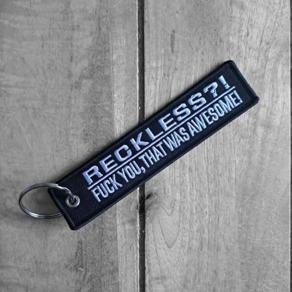 Embroidered reckless biker keytag angled on wooden background