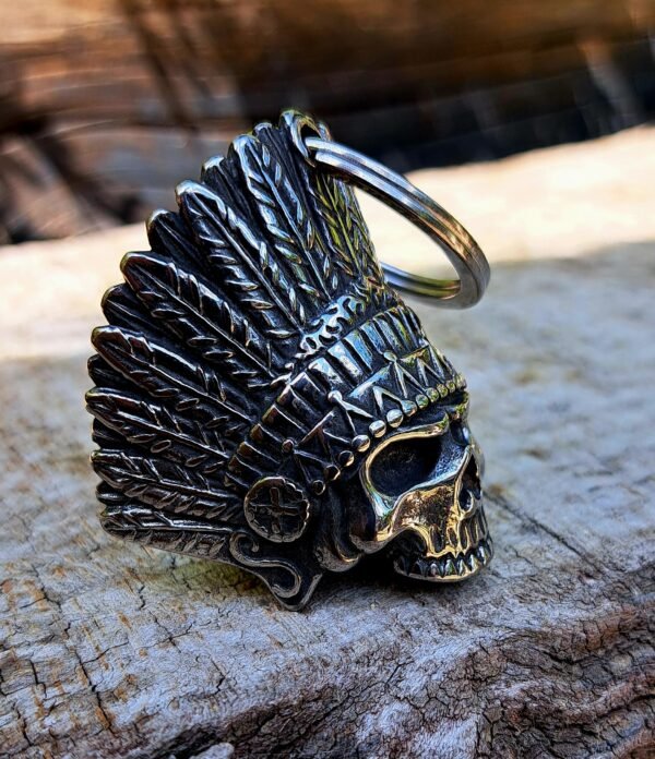 Side view of stainless steel gremlin bell with feathered skull design