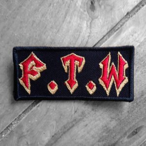 Embroidered F.T.W. patch with red Gothic-style lettering outlined in gold on a black background.