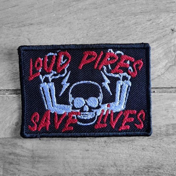 Embroidered biker patch with skull and exhaust pipes, featuring the text "Loud Pipes Save Lives" in red on dark background.