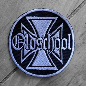Embroidered circular patch with light blue Iron Cross background and “Oldschool” in gothic text, on a black base.