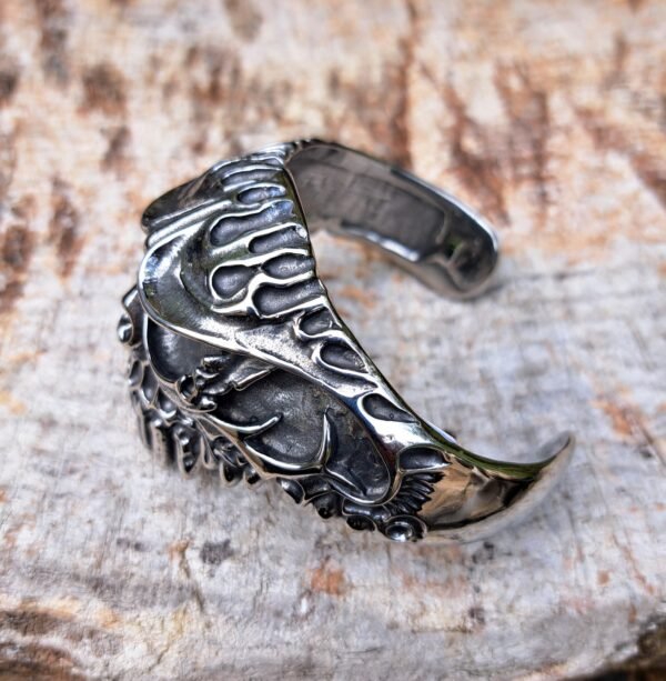 Heavy metal biker skull bangle bracelet with flame details in stainless steel, 69mm inside diameter.