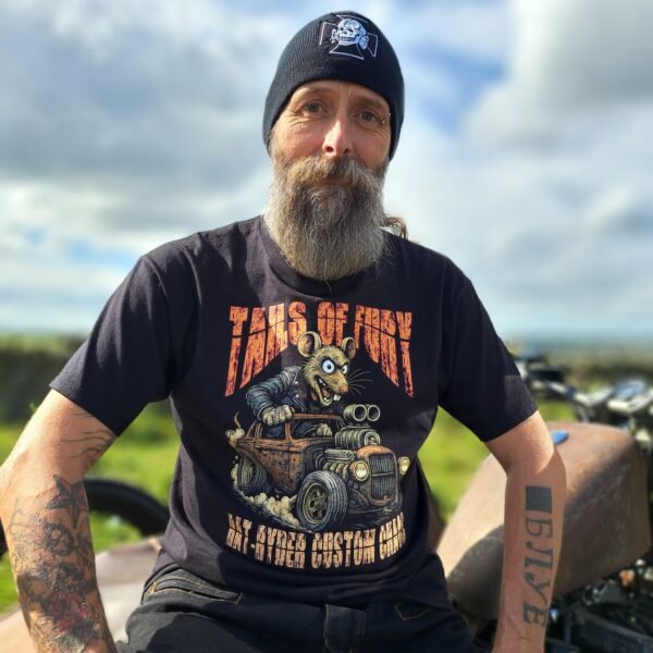 Black Rat-Ryder t-shirt with Lou the Rat driving a hot rod and the phrase “Tails of Fury,” Rat-Ryder Custom Chaos design, lifestyle shot beside a custom bike.
