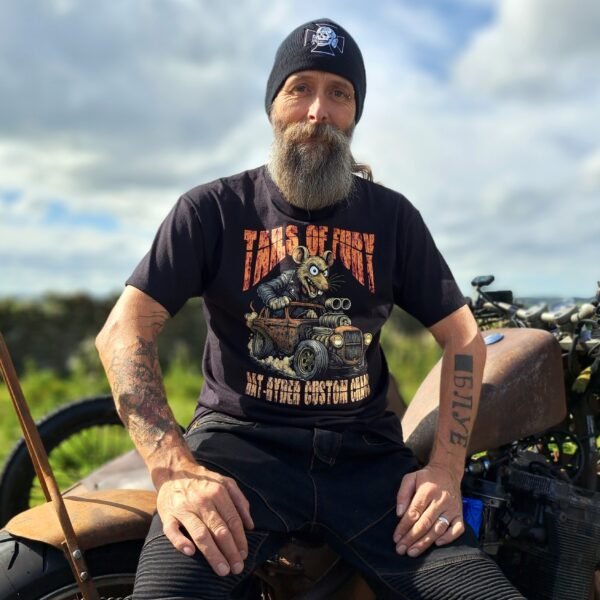 Person wearing Lou the Rat “Tails of Fury” hot-rod t-shirt by Rat-Ryder next to a custom motorcycle; black graphic tee.