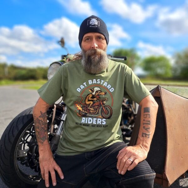 Biker lifestyle photo wearing the Rat-Ryder Rat Bastard Riders olive t-shirt beside a custom motorcycle; rugged garage-built style.