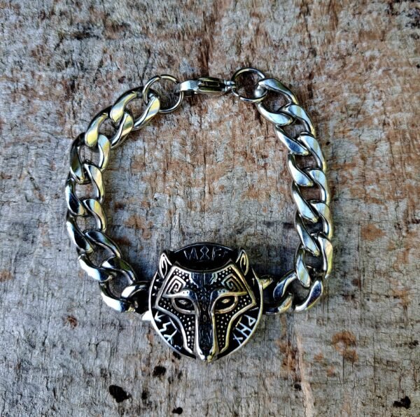 Stainless steel Fenrir bracelet with wolf head and Viking runes on wood background