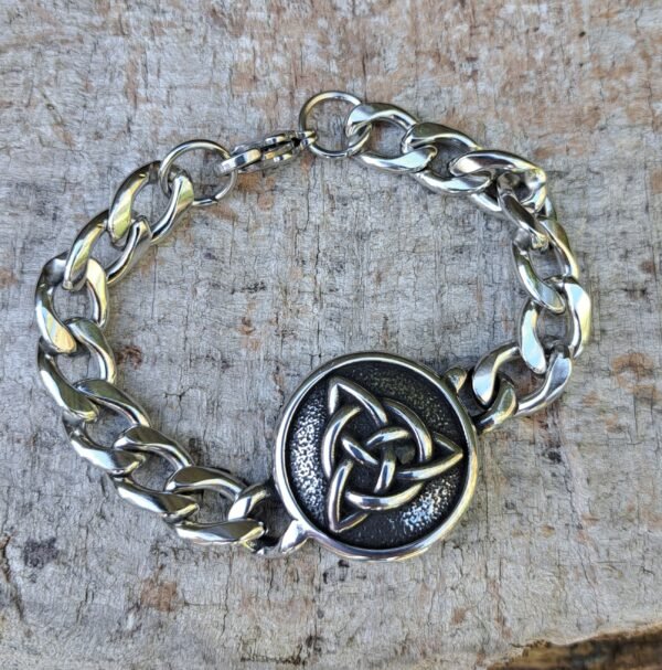 Viking stainless steel bracelet with Triquetra knot on rustic wooden background