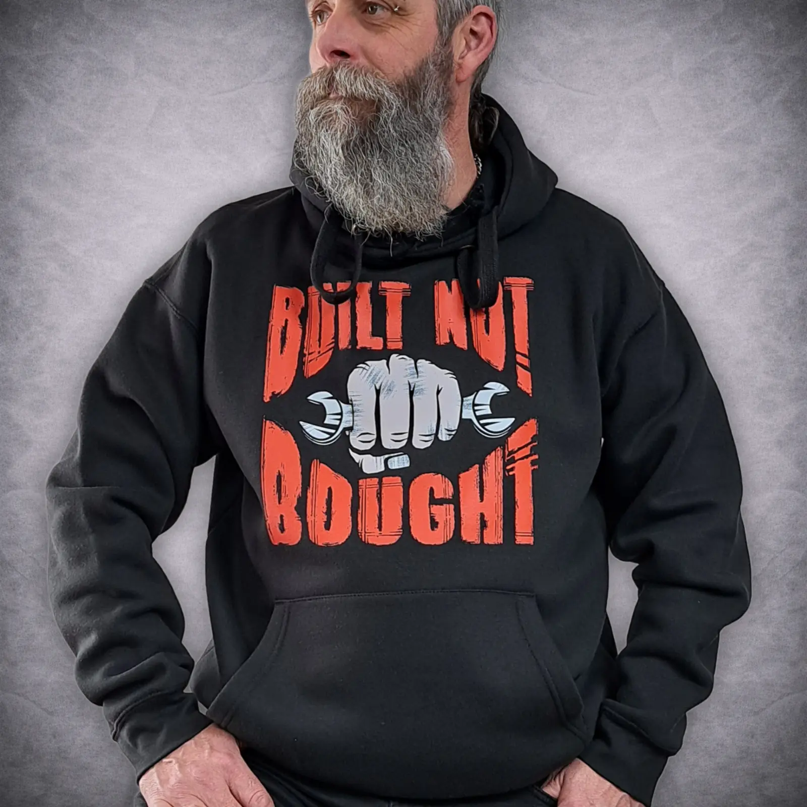 Built Not Bought Biker Hoodie | Motorcycle Mechanic Pullover 1 Built Not Bought biker hoodie showing the orange text and spanner fist front graphic on a model.