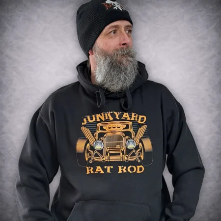 Side profile close-up of a man wearing the black Junkyard Rat Rod hoodie showing the vibrant orange custom car graphic print.