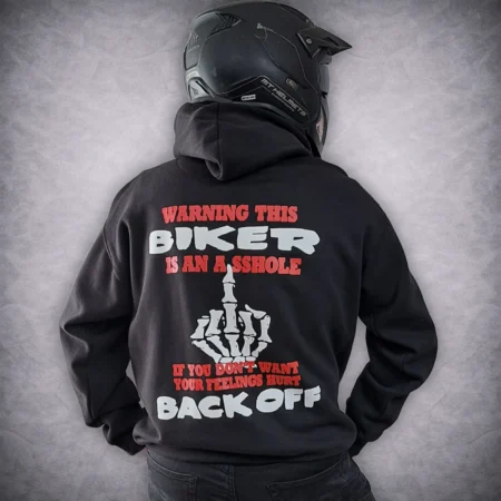 Rear view of a rider wearing a motorcycle helmet and the black Warning This Biker Is An Asshole slogan hoodie.