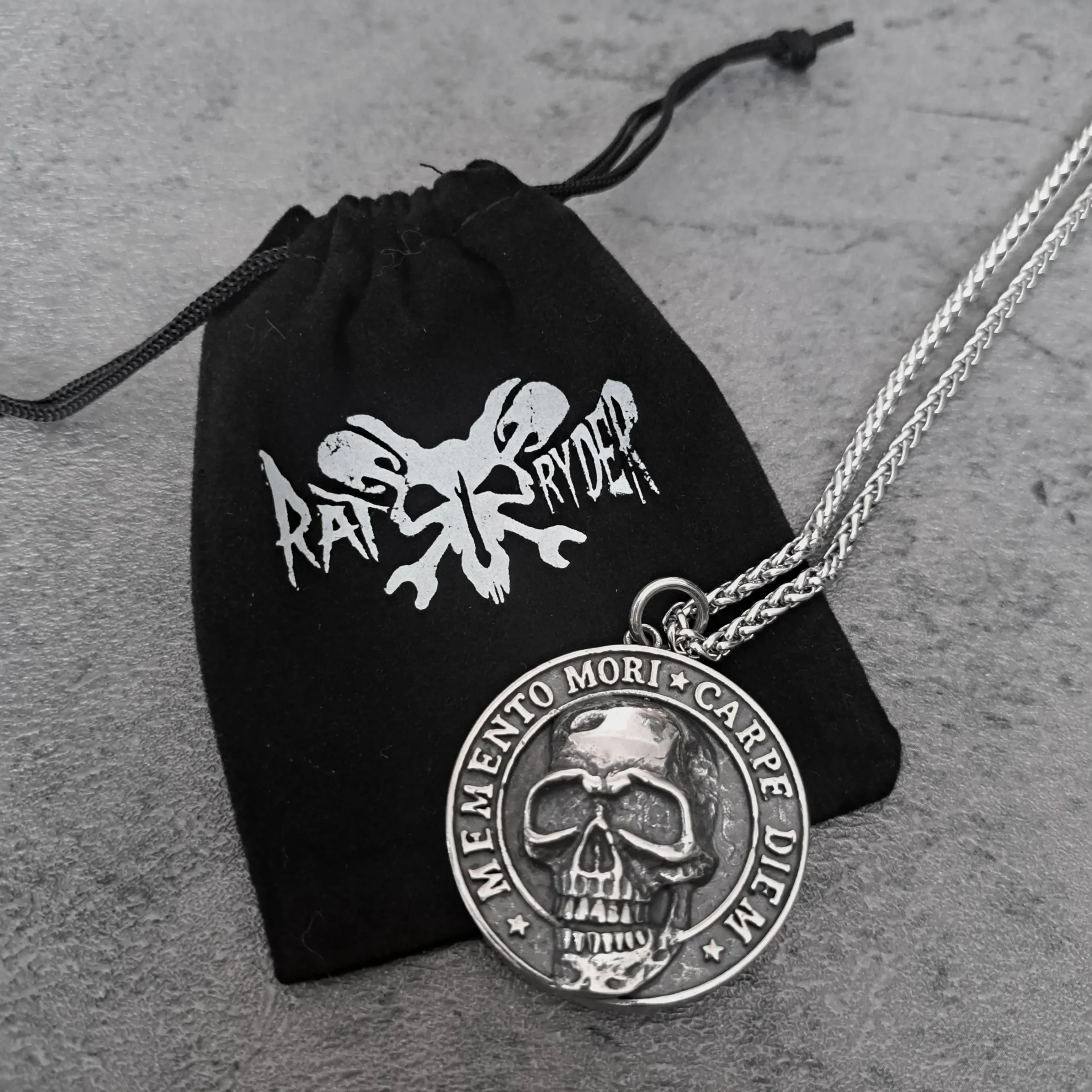 Memento Mori Carpe Diem Skull – 316L Stainless Steel Biker Pendant | RatRyder 3 Memento Mori Carpe Diem skull biker pendant resting on black RatRyder velvet gift bag