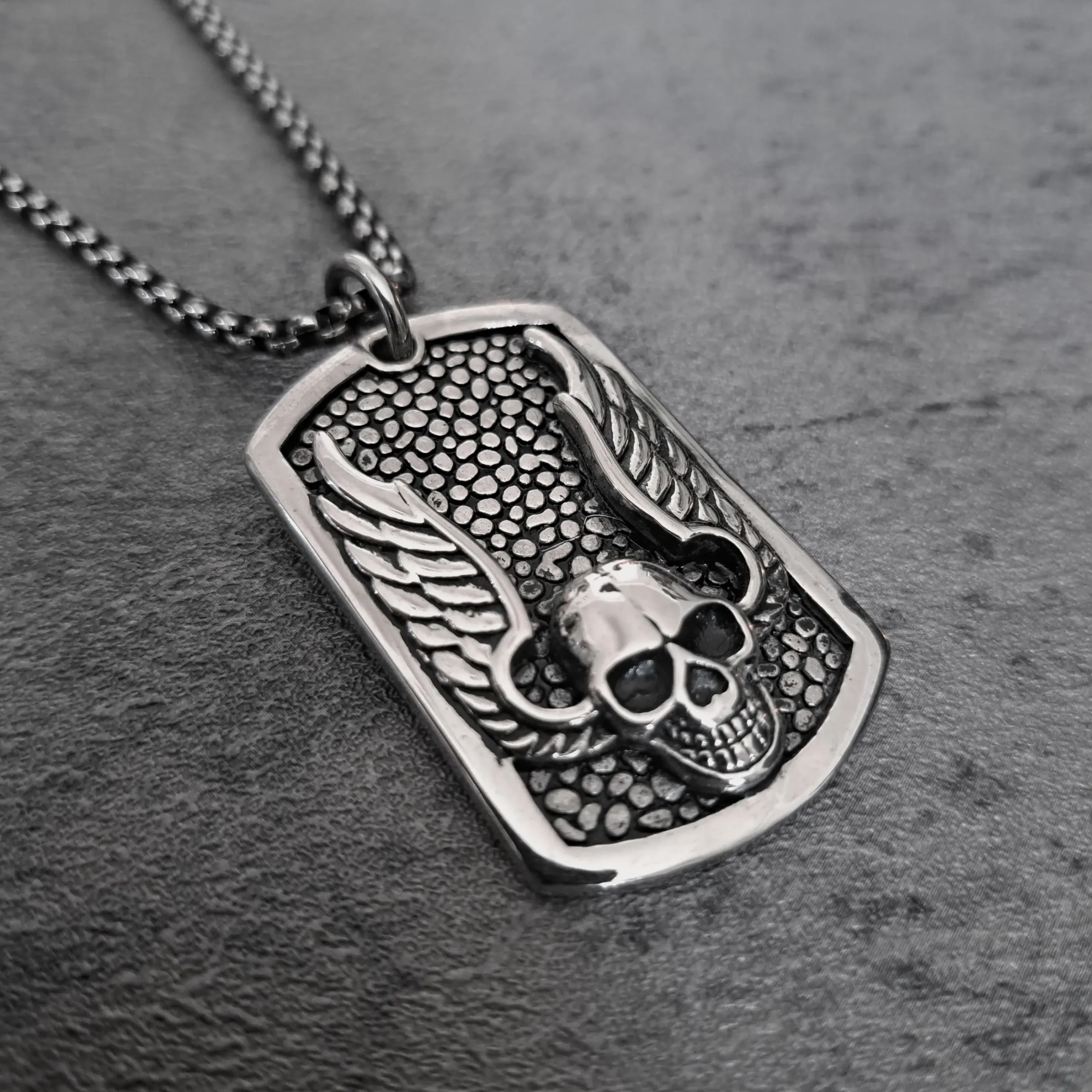 Winged Skull Dog Tag – Heavyweight 316L Stainless Steel Biker Pendant | RatRyder 2 Angled view of winged skull dog tag stainless steel biker pendant