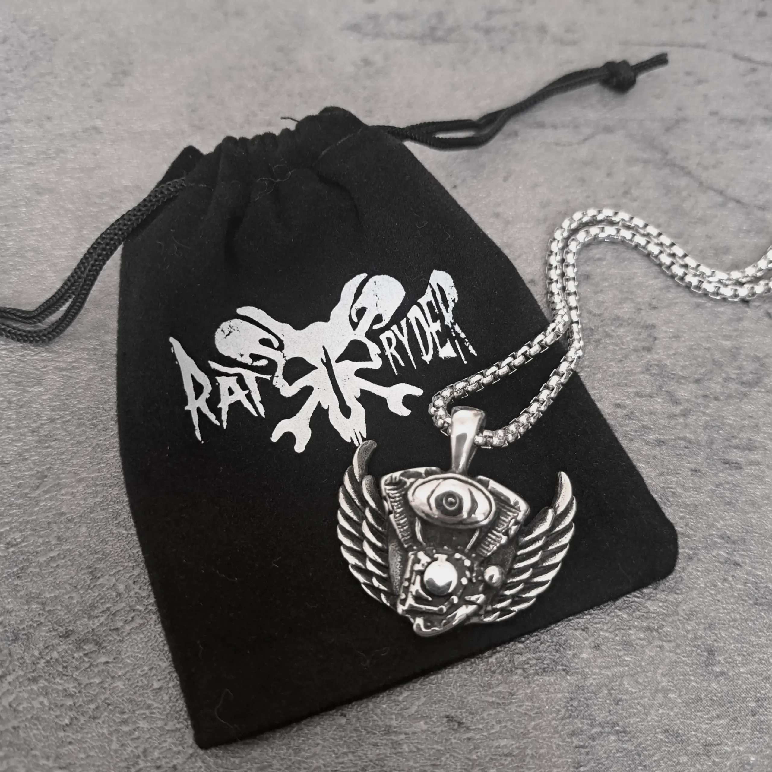 Winged V-Twin Engine – 316L Stainless Steel Harley Biker Pendant | RatRyder 3 Winged V-twin engine biker pendant resting on black RatRyder velvet gift bag